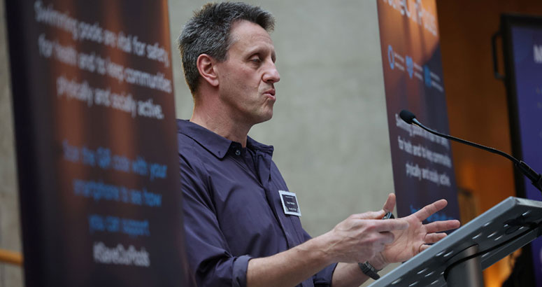 Man standing speaking at podium