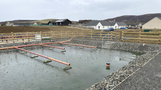 The new aerated reed bed that has been installed as part of Orphir WWTW, with the village beyond